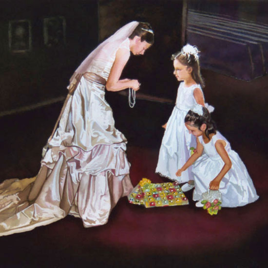 2 five-year-old girls dressed in white gowns being given necklaces by a woman in a wedding dress
