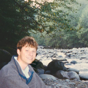 young Tom sitting next to rapids